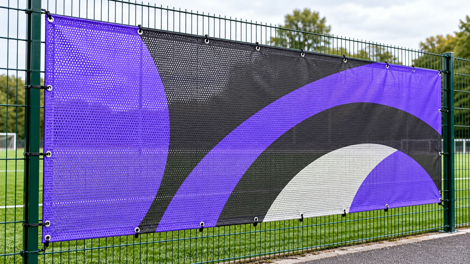Printed mesh banner with eyelets fixed to a sports-ground fence
